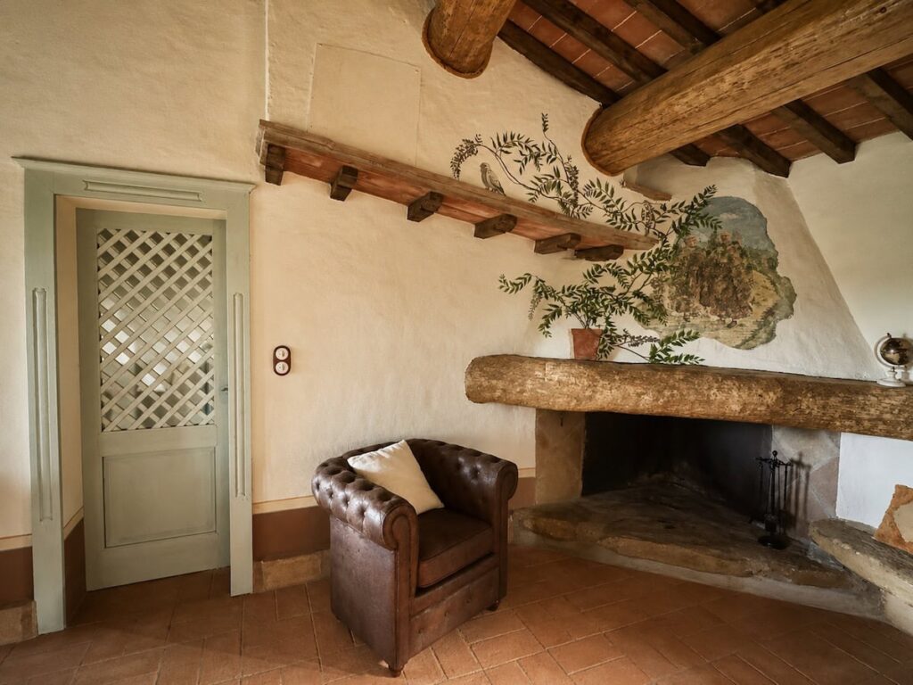 Living room with fireplace and doorway in the Il belvedere apartment, Borgo Braila, Umbria