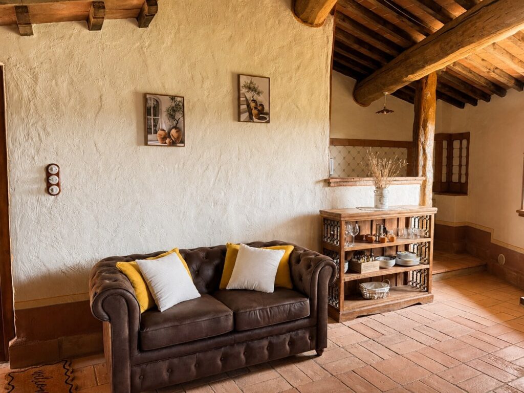 Living room with a leather sofa and shelving in the Il belvedere apartment, Borgo Braila, Umbria