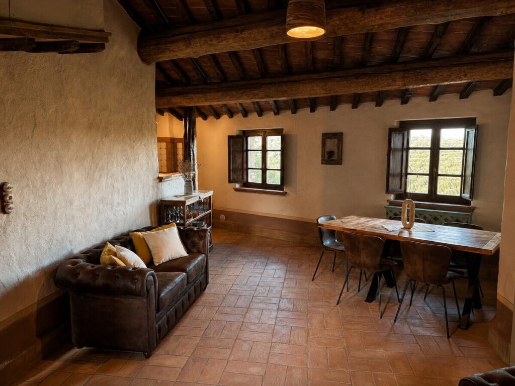 Living and dining room with sofa and table in the Il belvedere apartment, Borgo Braila, Umbria