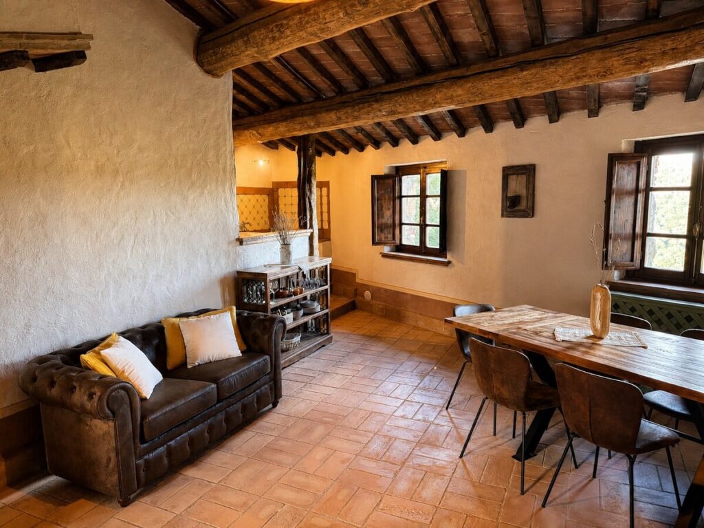 Living room with sofa, dining table and window in the Il belvedere apartment, Borgo Braila, Umbria