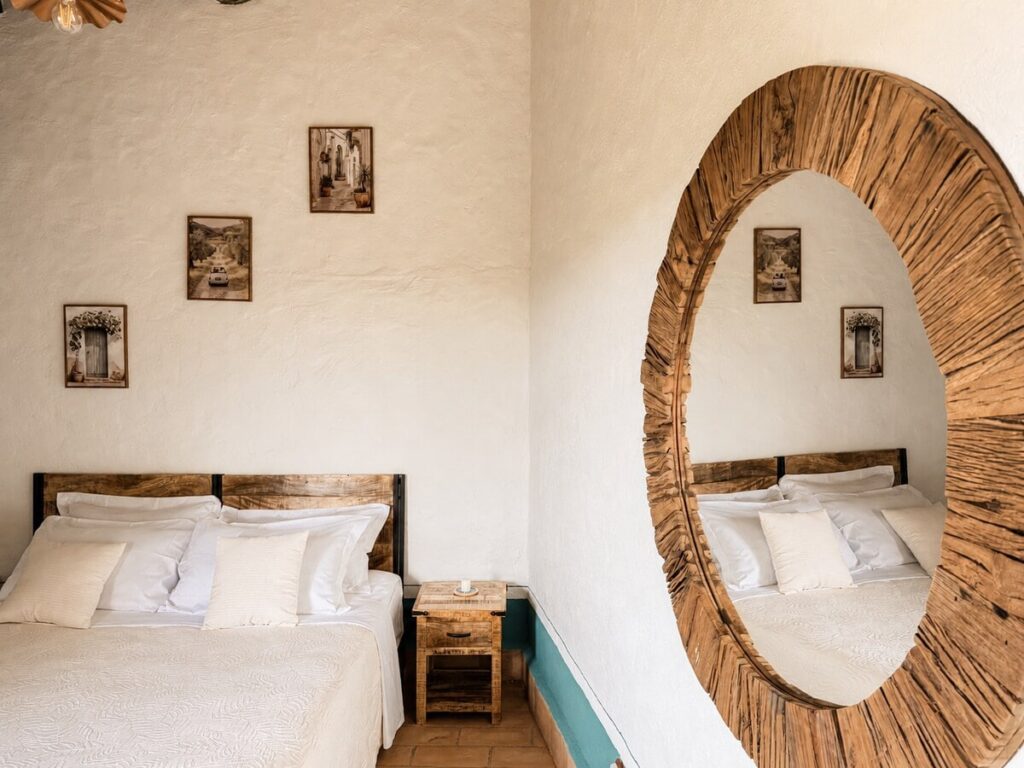 Bedroom with a double bed and round mirror in the Il belvedere apartment, Borgo Braila, Umbria