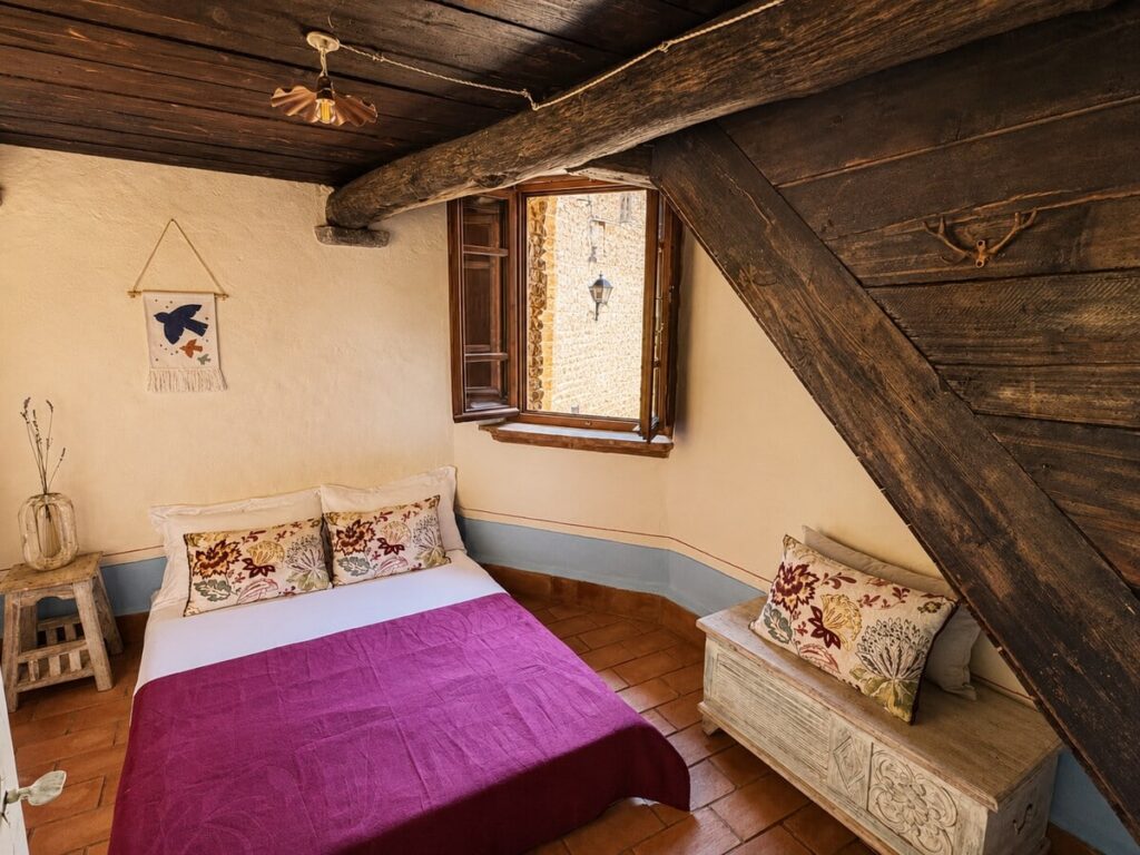 Bedroom with a double bed and window in the Il belvedere apartment, Borgo Braila, Umbria