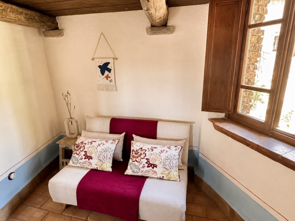 Bedroom with a sofa bed and window in the Il belvedere apartment, Borgo Braila, Umbria