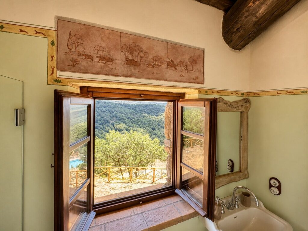 Bathroom with a window view and sink in the Il belvedere apartment, Borgo Braila, Umbria