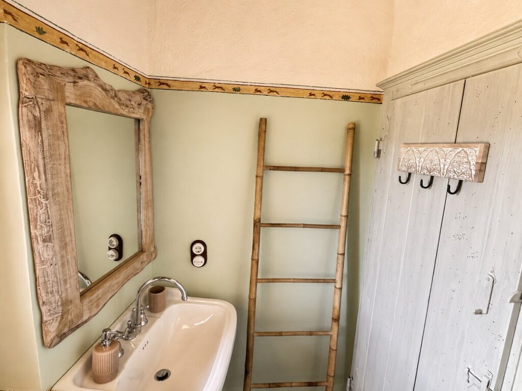 Bathroom with a sink and ladder shelf in the Il belvedere apartment, Borgo Braila, Umbria