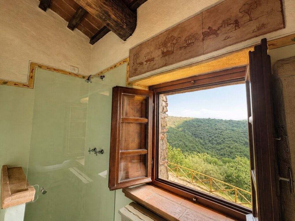 Bathroom window with a countryside view in the Il belvedere apartment, Borgo Braila, Umbria