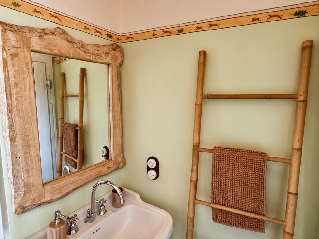 Bathroom with a mirror and ladder shelf in the Il belvedere apartment, Borgo Braila, Umbria
