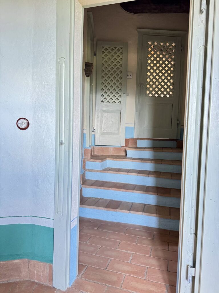 Hallway with a doorway and staircase in the Il belvedere apartment, Borgo Braila, Umbria