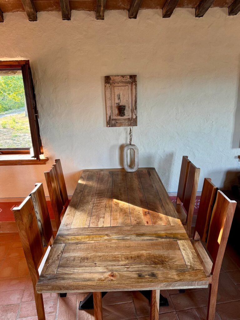 Rustic wooden dining table beside the window in the Il cavaliere apartment, Borgo Braila, Umbria