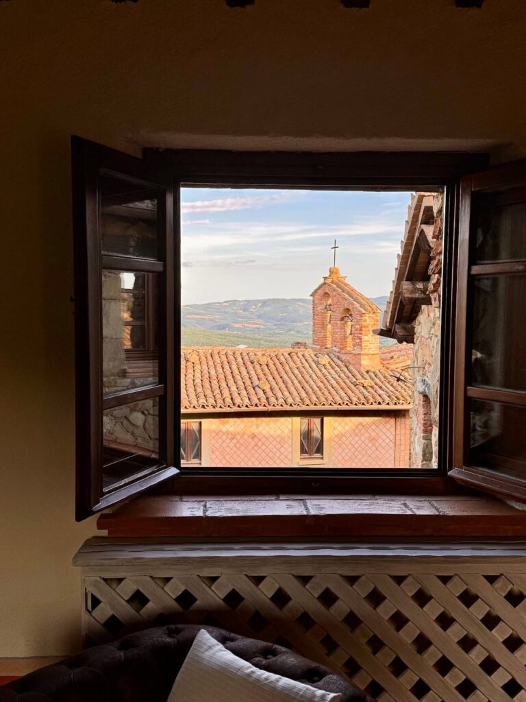 Window framing a view over the medieval village in the Il cavaliere apartment, Borgo Braila, Umbria