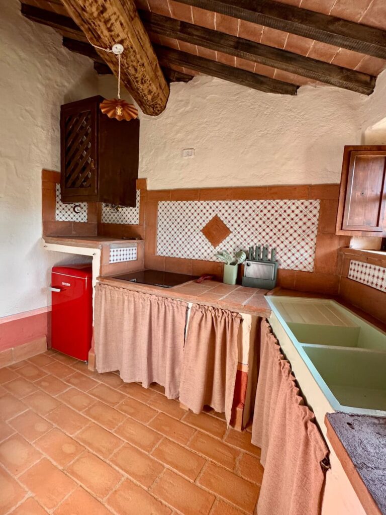 Country kitchen with a retro red refrigerator in the Il cavaliere apartment, Borgo Braila, Umbria