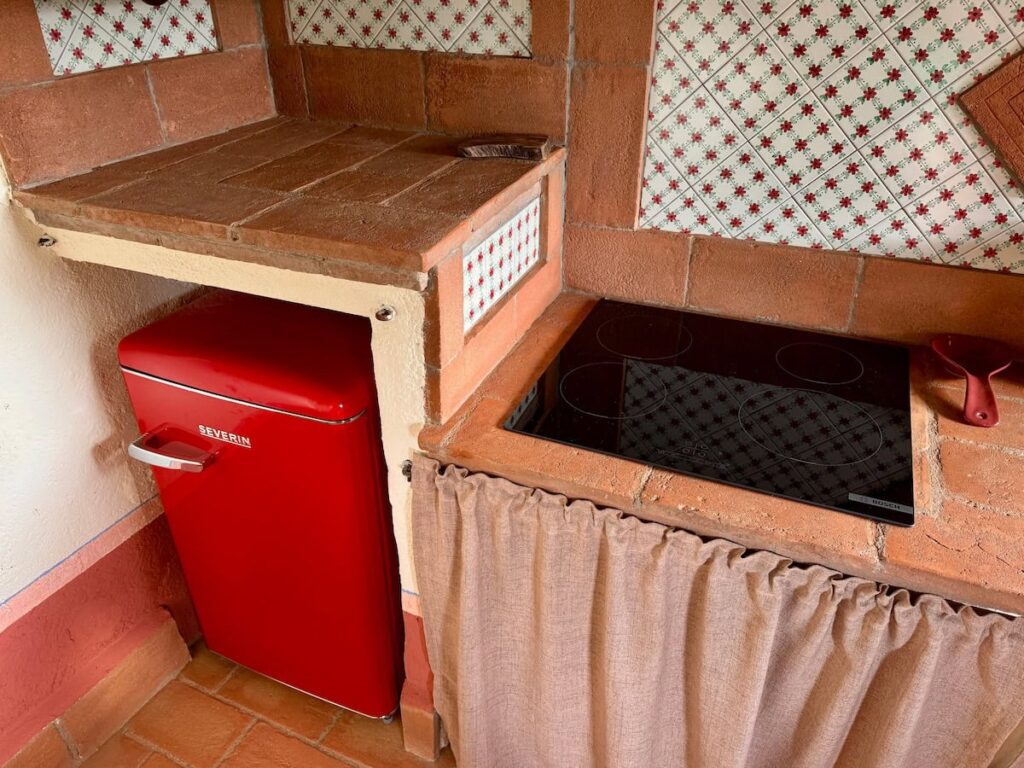 Kitchen corner with retro red fridge and hob in the Il cavaliere apartment, Borgo Braila, Umbria