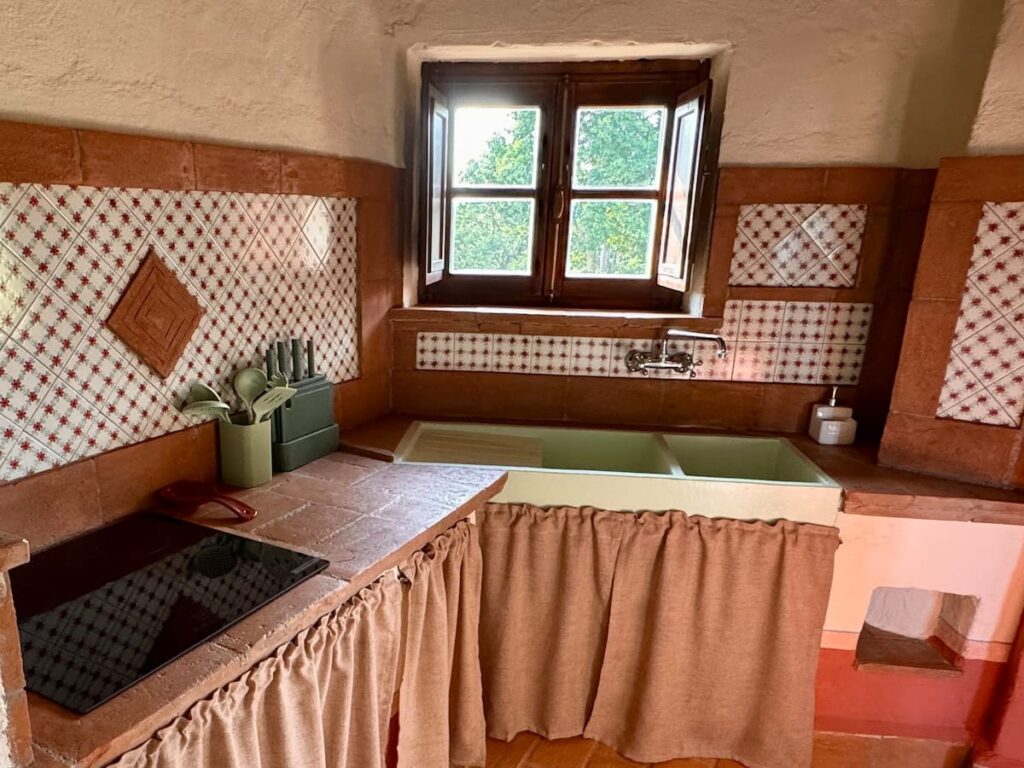 Kitchen with sink and hand-tiled splashback in the Il cavaliere apartment, Borgo Braila, Umbria