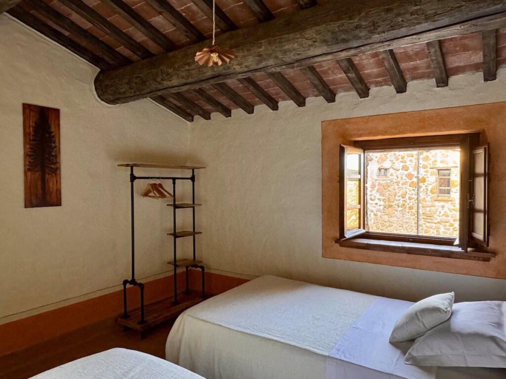 Bedroom with double bed and countryside window in the Il cavaliere apartment, Borgo Braila, Umbria