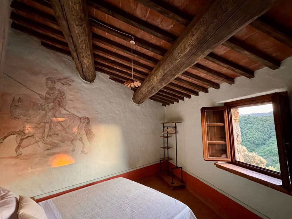 Bedroom with a hand-painted knight fresco in the Il cavaliere apartment, Borgo Braila, Umbria