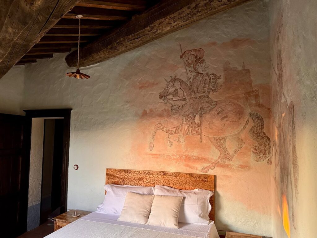 Bedroom with a knight-on-horseback wall fresco in the Il cavaliere apartment, Borgo Braila, Umbria