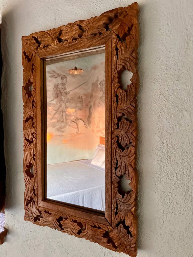 Detail of a carved wooden wall mirror in the Il cavaliere apartment, Borgo Braila, Umbria
