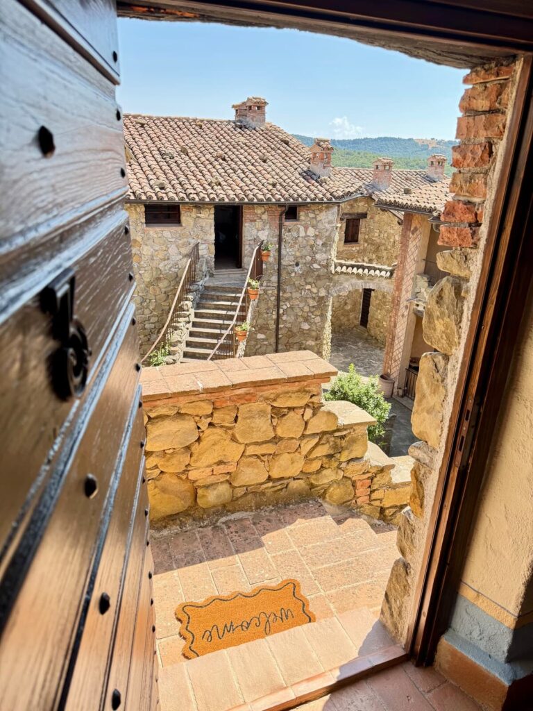 Open window with a view of the village in the La carta apartment, Borgo Braila, Umbria