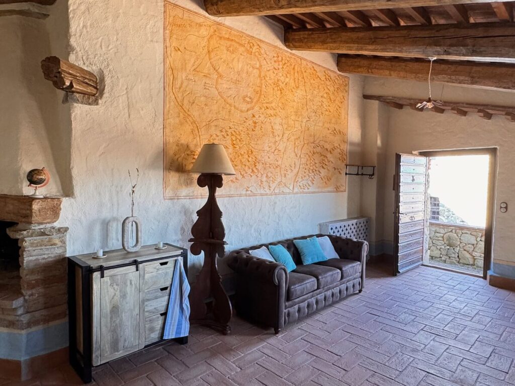 Living room with a wooden dresser in the La carta apartment, Borgo Braila, Umbria