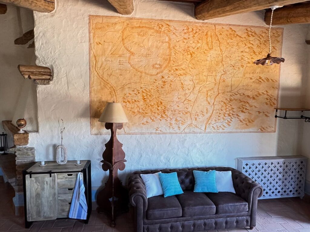 Living room with a sofa and reading lamp in the La carta apartment, Borgo Braila, Umbria