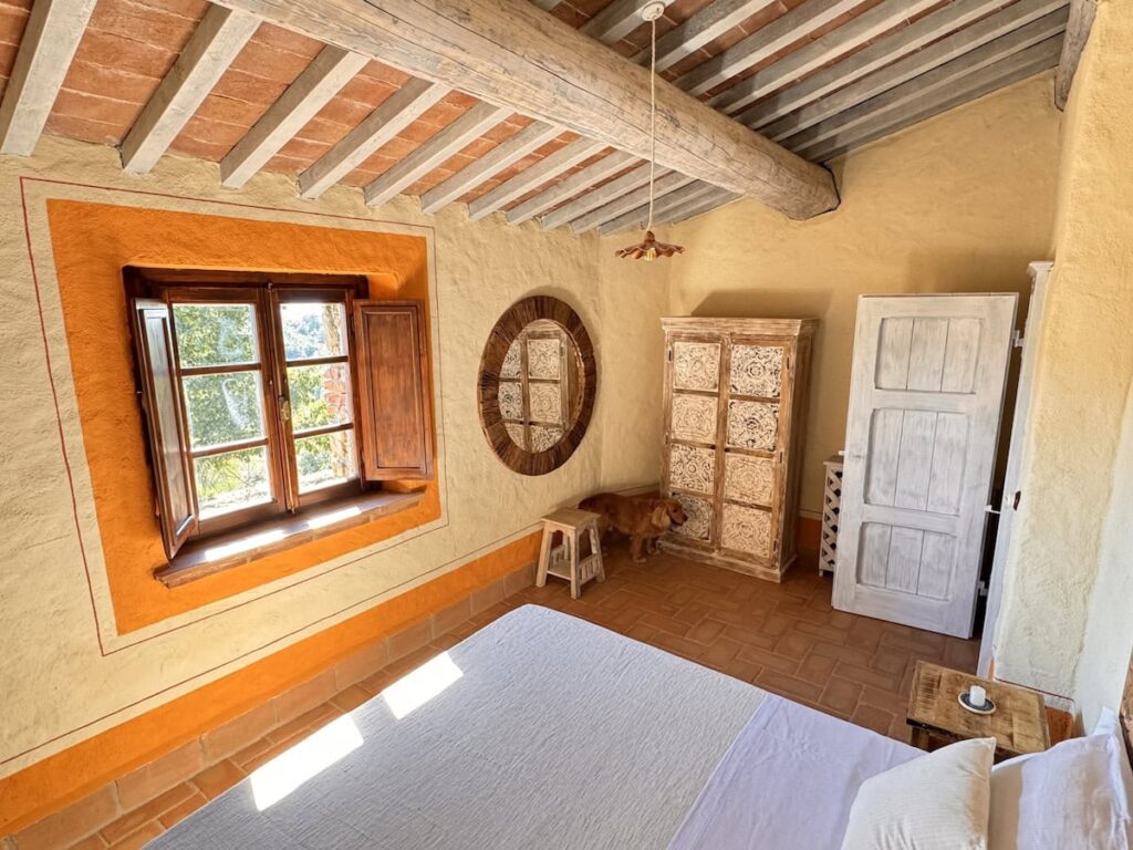 Bedroom with a double bed and window in the La carta apartment, Borgo Braila, Umbria