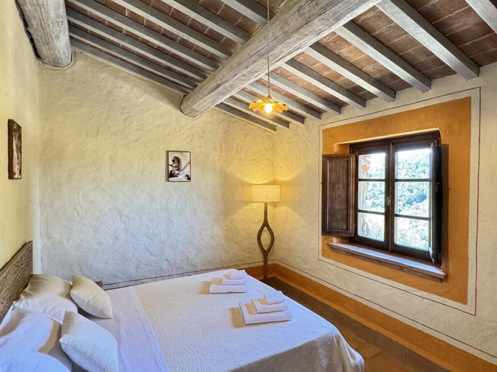 Bedroom with a double bed in the La carta apartment, Borgo Braila, Umbria