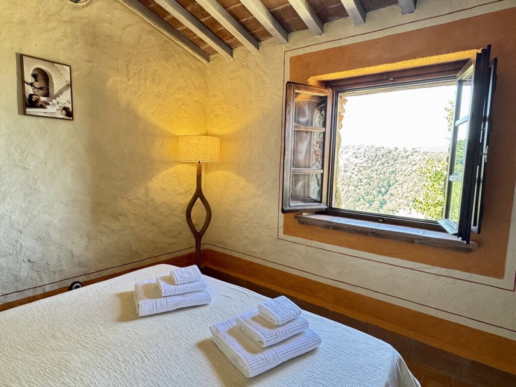 Bedroom with a double bed and window in the La carta apartment, Borgo Braila, Umbria