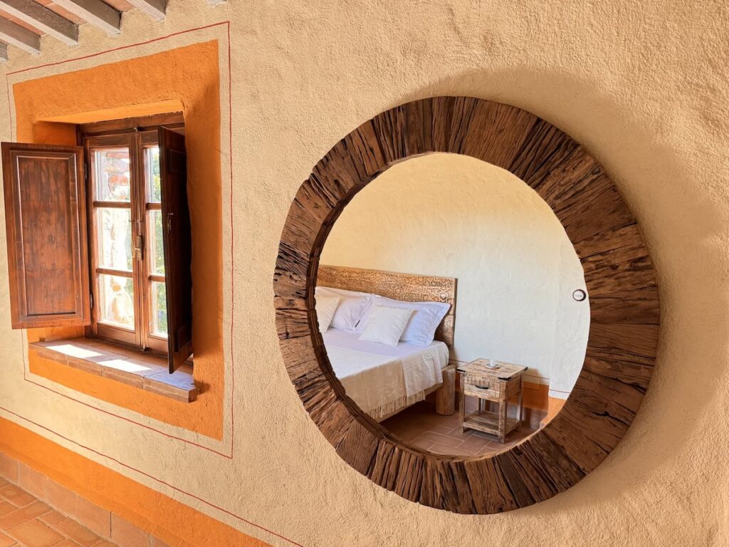 Round wooden wall mirror in the La carta apartment, Borgo Braila, Umbria