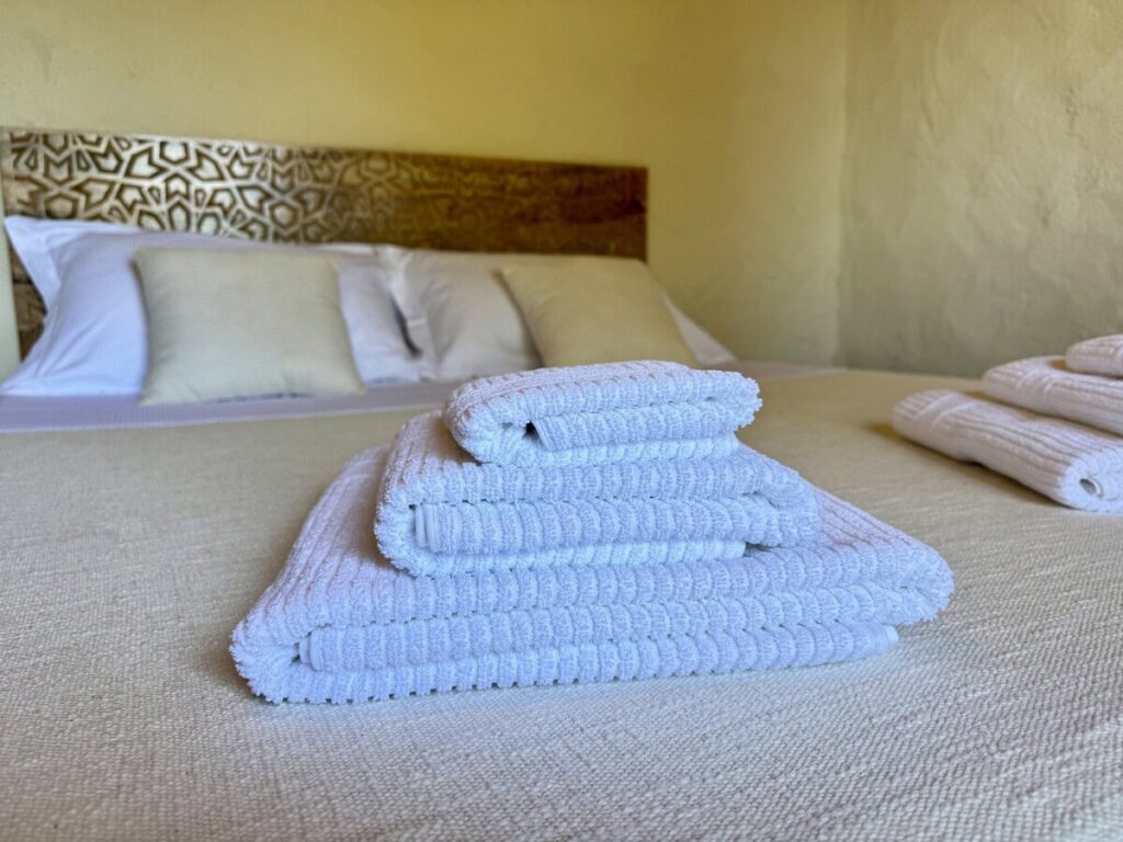 Bedroom with a double bed and fresh towels in the La carta apartment, Borgo Braila, Umbria