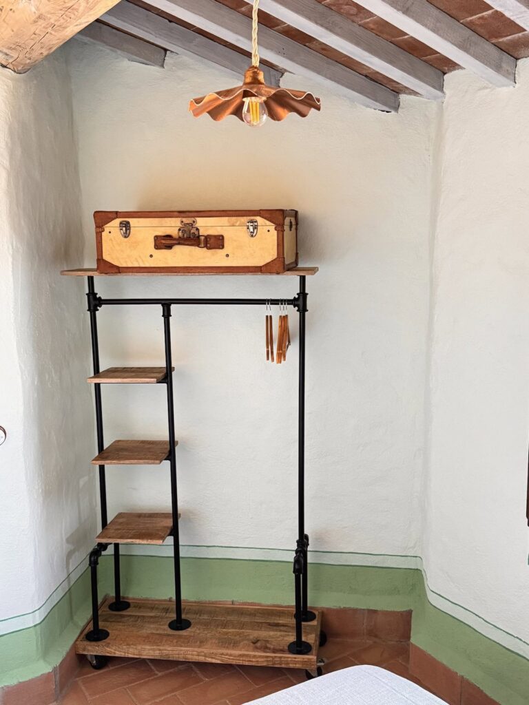Bedroom with a ladder shelf in the La carta apartment, Borgo Braila, Umbria