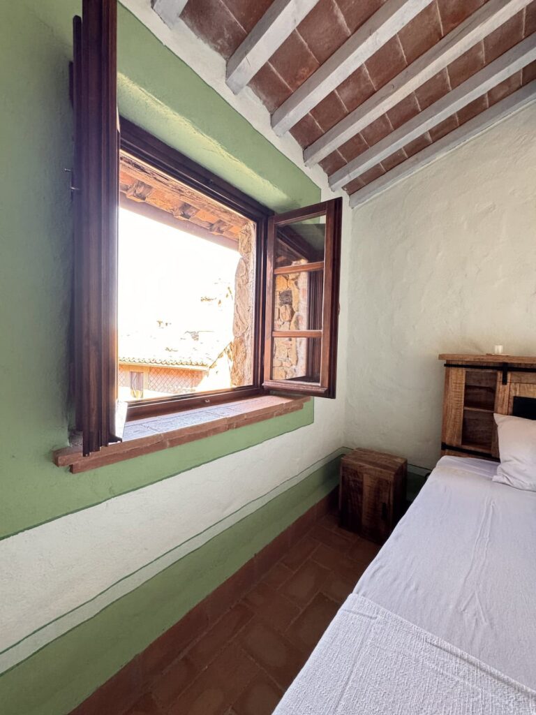 Bedroom with a window in the La carta apartment, Borgo Braila, Umbria