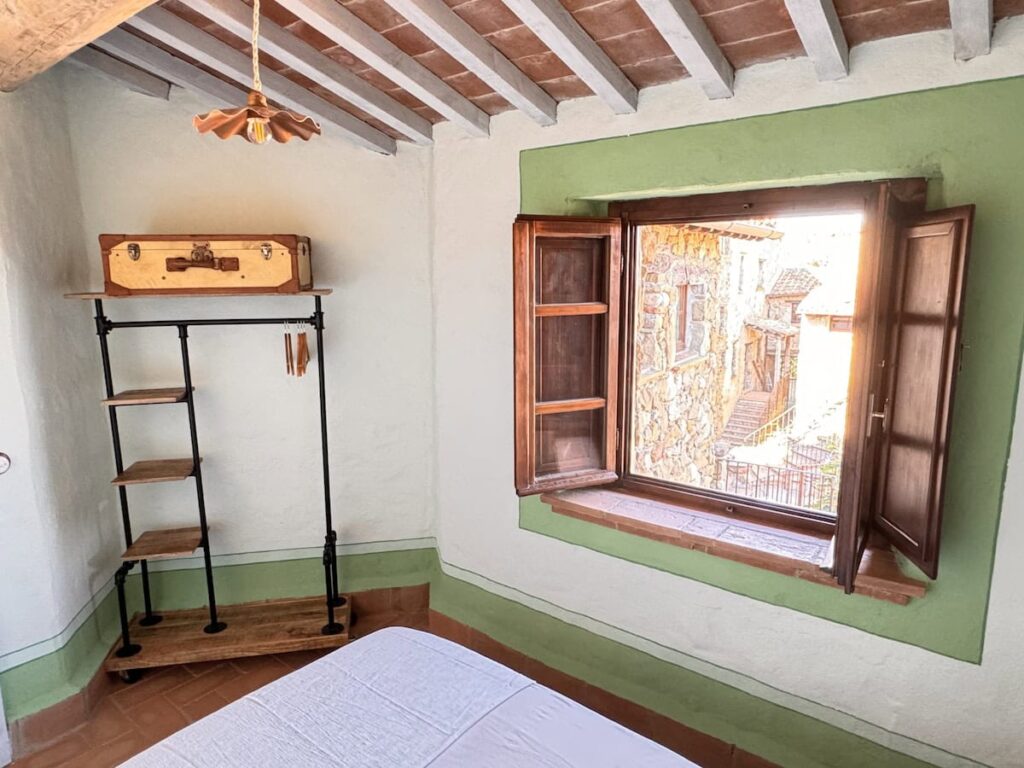 Bedroom with a bed and window in the La carta apartment, Borgo Braila, Umbria