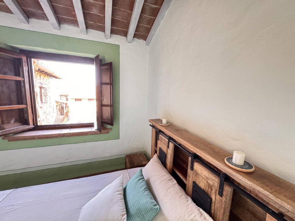 Bedroom with a double bed in the La carta apartment, Borgo Braila, Umbria