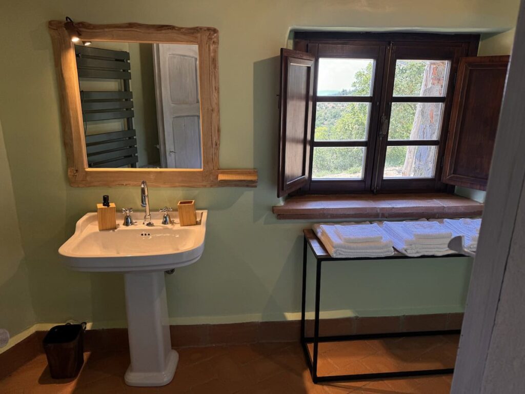 Bathroom with a sink and window view in the La carta apartment, Borgo Braila, Umbria