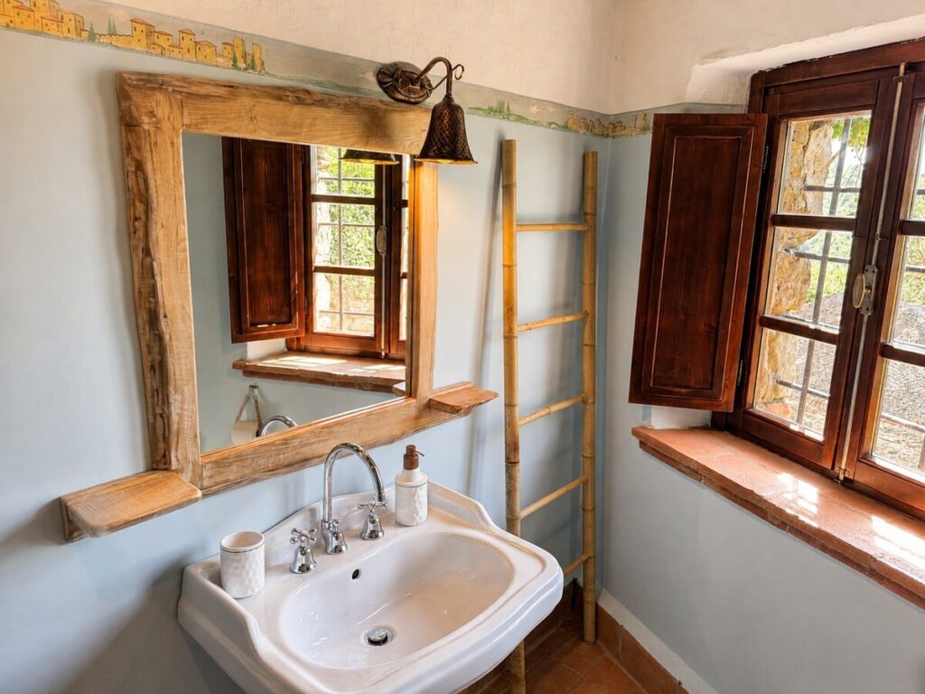 Bathroom with a pedestal sink and window in the Il ponente apartment, Borgo Braila, Umbria