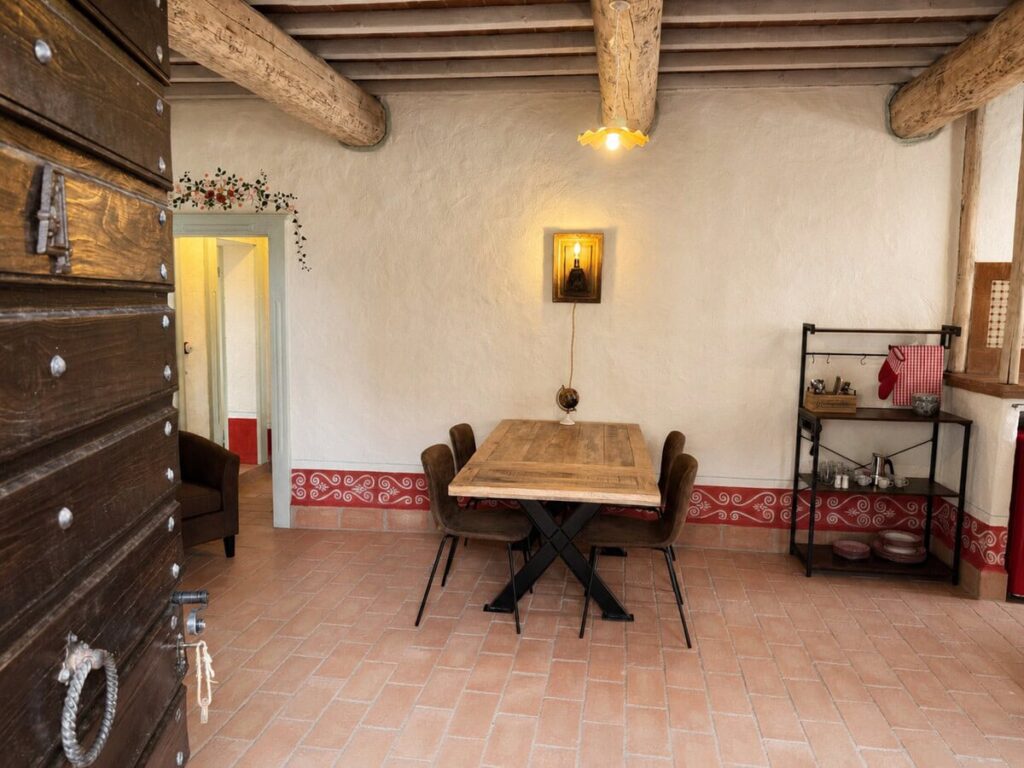 Living room with a wooden dresser and dining area in the Il ponente apartment, Borgo Braila, Umbria