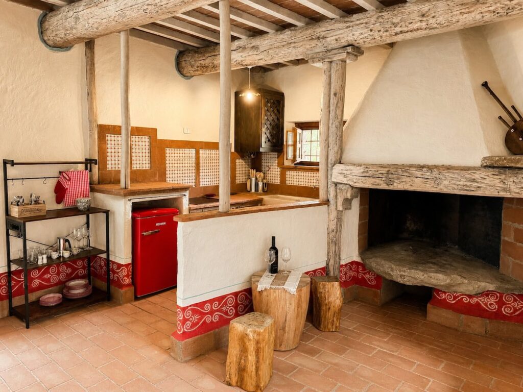 Living room with a fireplace and kitchen corner in the Il ponente apartment, Borgo Braila, Umbria