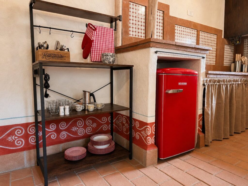 Country kitchen with a retro red refrigerator in the Il ponente apartment, Borgo Braila, Umbria