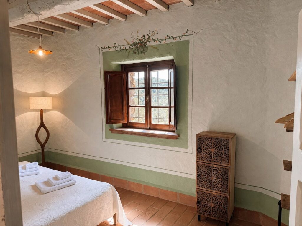 Bedroom with a bed and window in the Il ponente apartment, Borgo Braila, Umbria