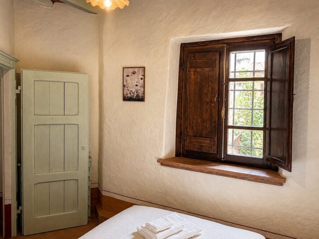 Bedroom with a bed and doorway in the Il ponente apartment, Borgo Braila, Umbria