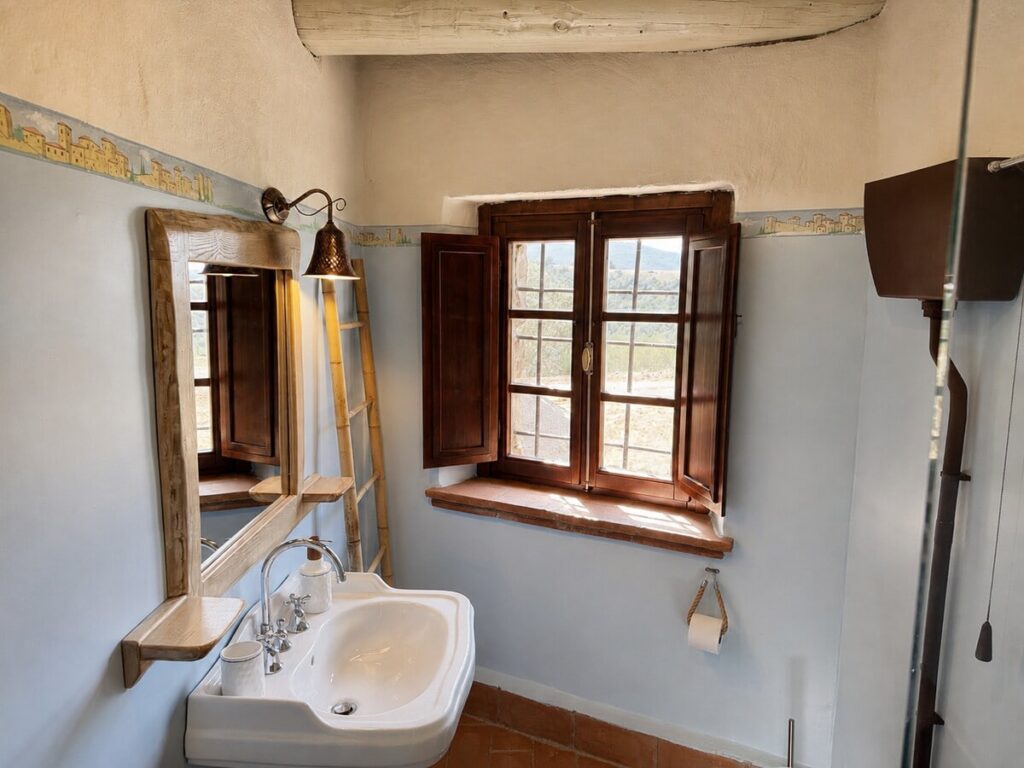 Bathroom with a sink and window in the Il ponente apartment, Borgo Braila, Umbria