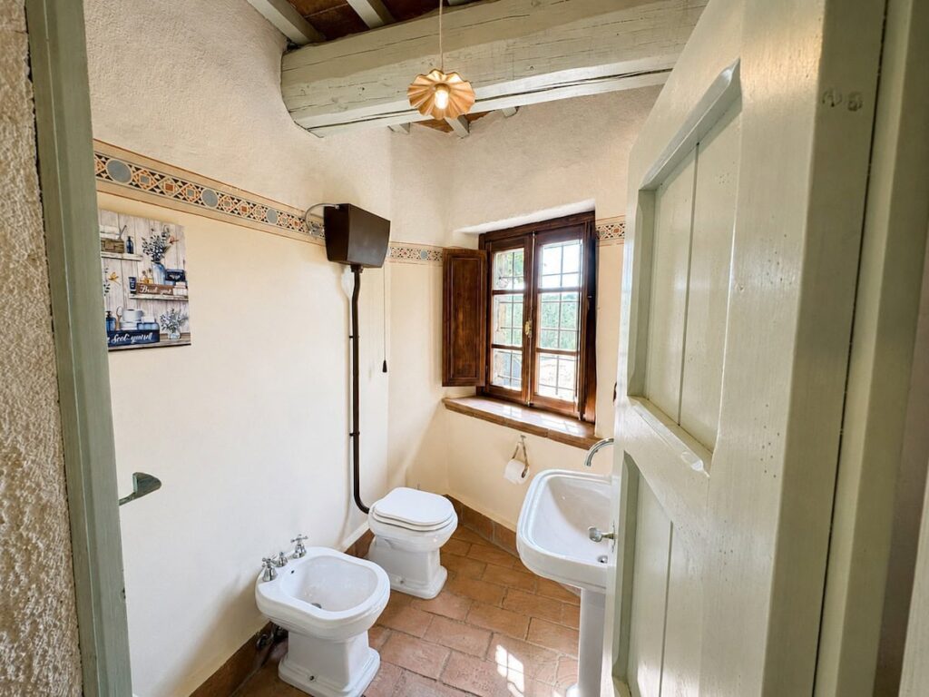 Bathroom with a bidet and window in the Il ponente apartment, Borgo Braila, Umbria
