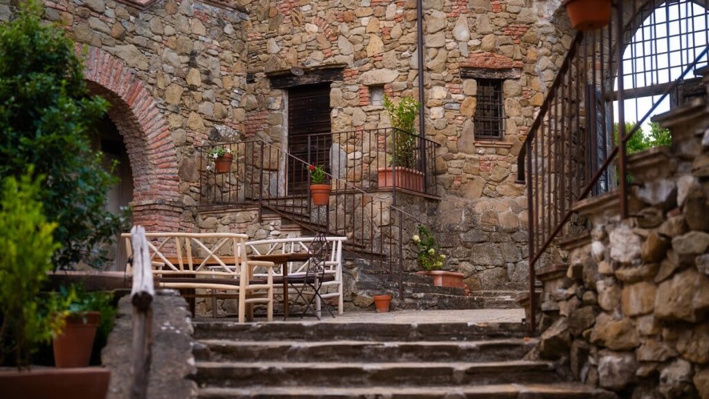 Stone archway with a courtyard table in the Il ponente apartment, Borgo Braila, Umbria