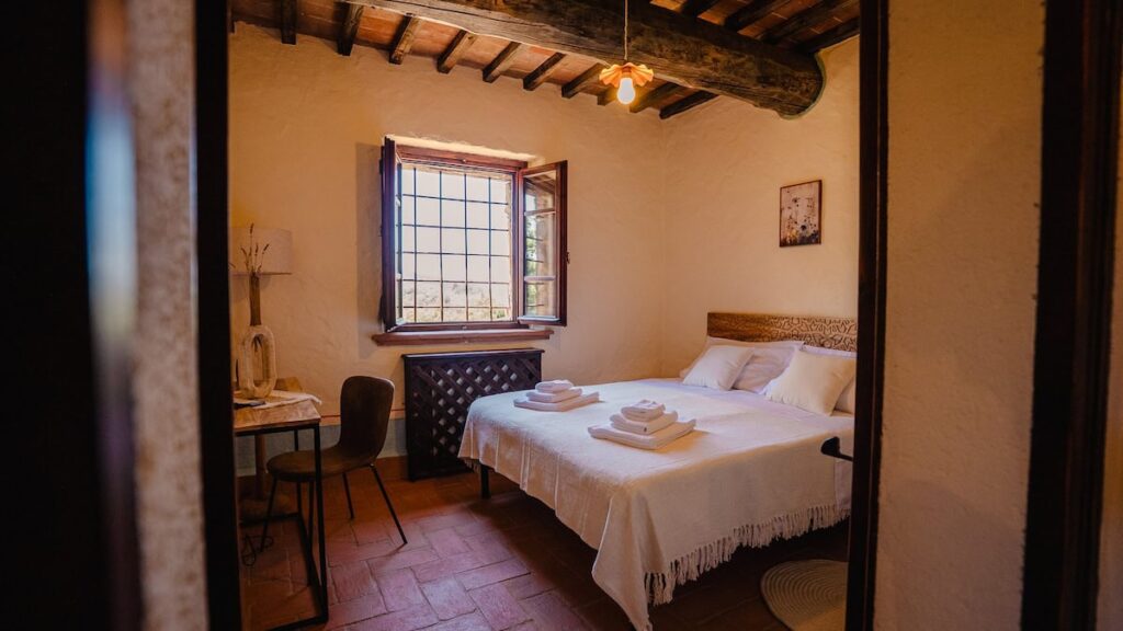 Bedroom with a double bed and window in the Il cardinale apartment, Borgo Braila, Umbria