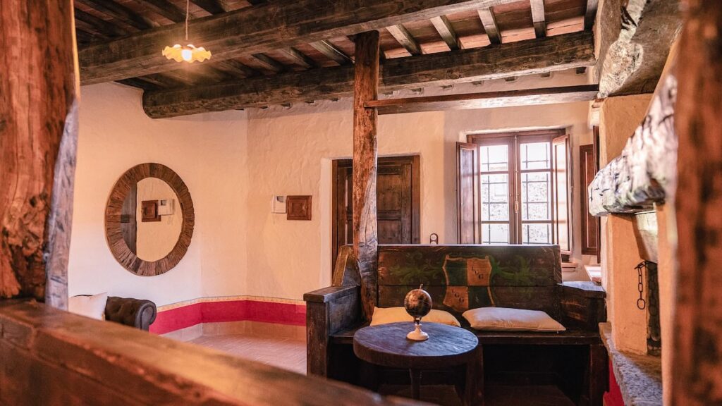 Living room with a round mirror and sofa in the Il cardinale apartment, Borgo Braila, Umbria