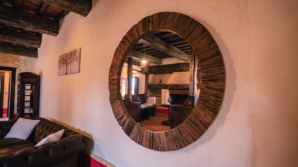 Living room with a round mirror in the Il cardinale apartment, Borgo Braila, Umbria