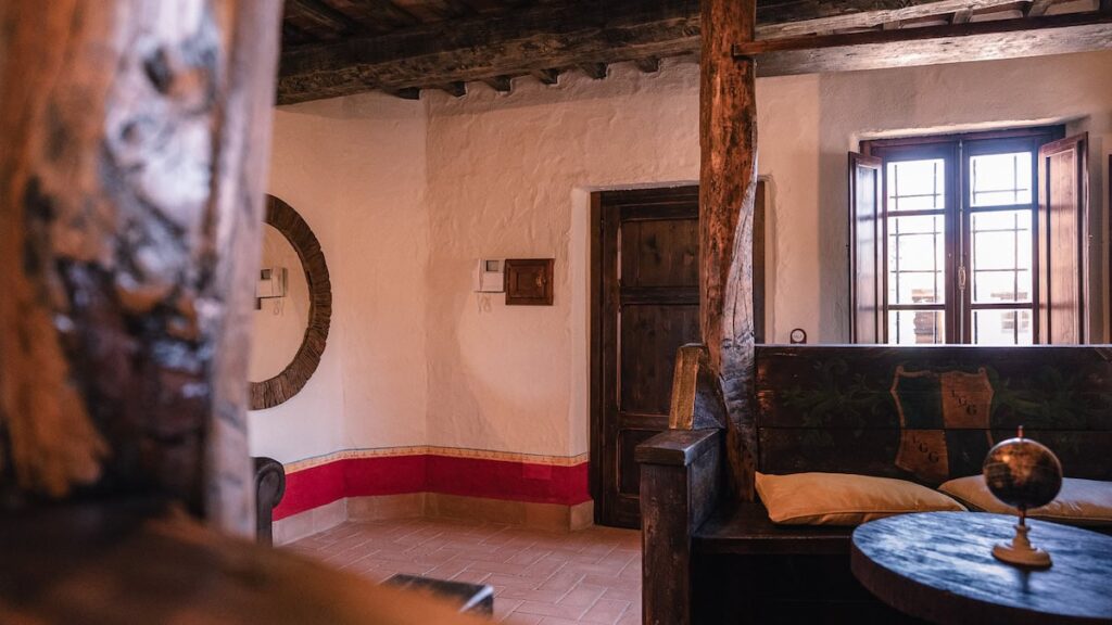 Living room with a sofa and beams in the Il cardinale apartment, Borgo Braila, Umbria