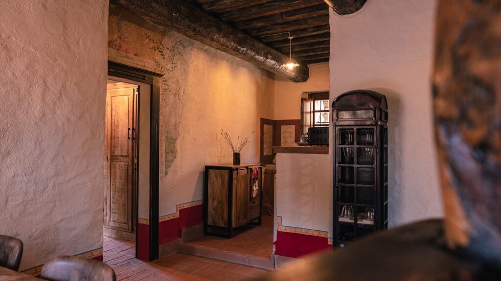 Hallway with a sofa and cushions in the Il cardinale apartment, Borgo Braila, Umbria