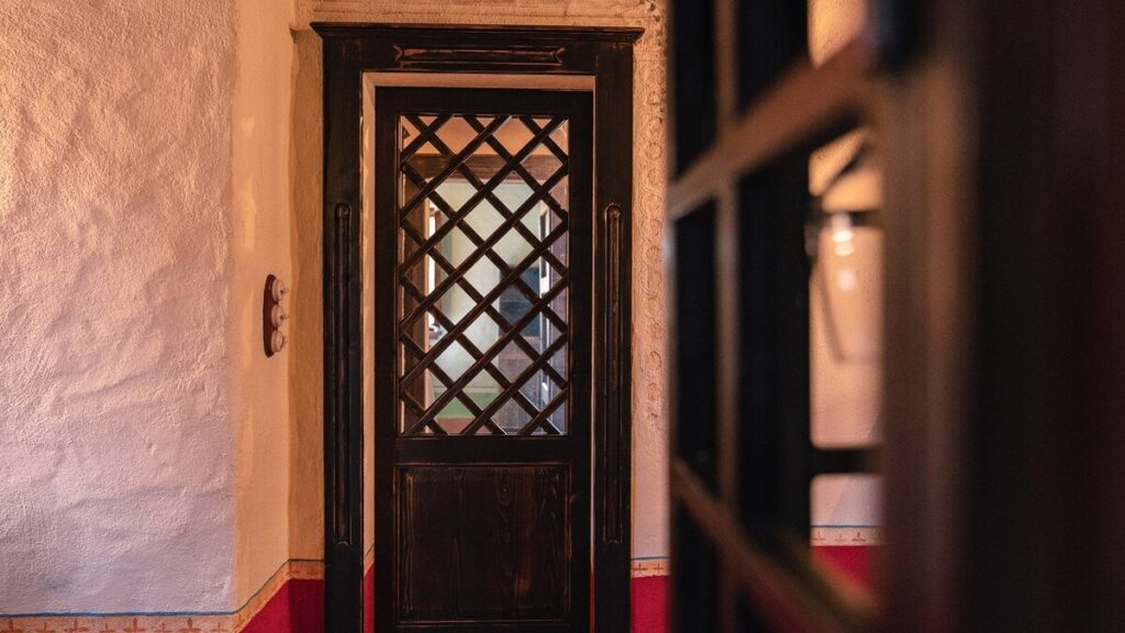 Wooden door with a lattice window in the Il cardinale apartment, Borgo Braila, Umbria
