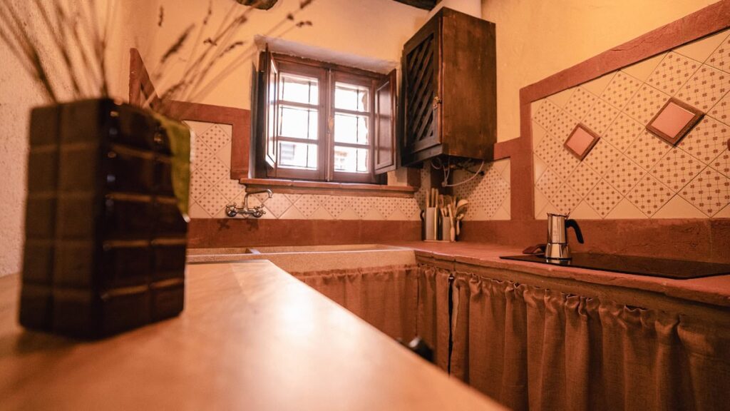 Kitchen with shelving and a window in the Il cardinale apartment, Borgo Braila, Umbria